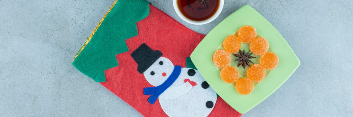 Tea cup and marmelade platter on a christmas sock on marble background. High quality photo